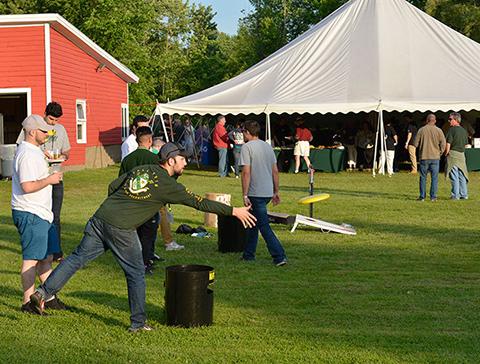 Alumnus throwing a frisbee during Reunion games