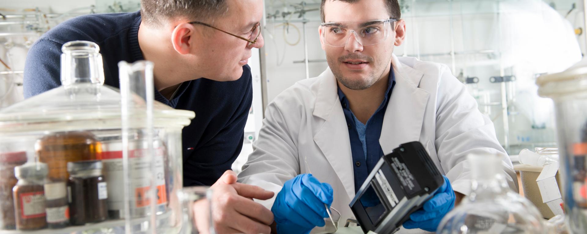 Professor Fehmi Damkaci and male student working in laboratory