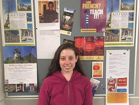 Serena Schaeber in front of bulletin board of opportunities