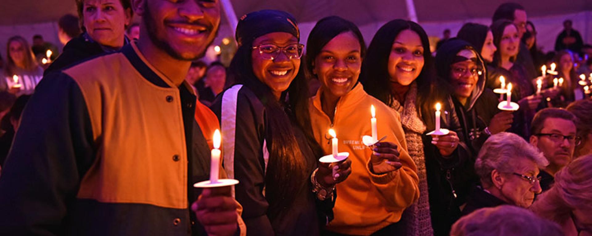 Group of students holding lit candles